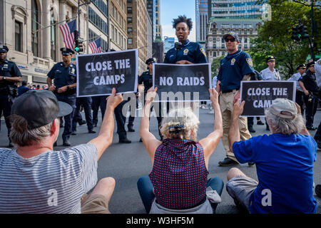 New York, Stati Uniti d'America. Il 15 luglio 2019. Più di 40 membri dell'azione diretta di gruppo e aumento di resist sono stati arrestati dopo la chiusura di ora di punta del traffico in corrispondenza dell'intersezione tra la 42nd Street e la Fifth Avenue nel cuore di New York City sulla luglio 15, 2019 raccomanda per i diritti degli immigrati ed esigente pubblico wake up, agire, e alla fine la crisi di confine il terrore e il terrore inflitti alla comunità di immigrati. Gli attivisti detenuti tre banner che leggere, 'chiudere i campi'', 'No incursioni'', e 'abolire il ghiaccio''. Alcuni membri indossava inoltre fluorescente giubbotti di lavoro con le parole 'abolire il ghiaccio. (Credito Foto Stock