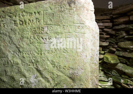 Graffiti sulle pietre all'interno Unstan chambered cairn, neolitico un tumulo sulla terraferma Orkney, Scotland, Regno Unito. Foto Stock