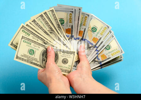 Mani 100 dollari. Tenere le mani di un sacco di soldi. Ventola out di banconote di dollari americani Foto Stock