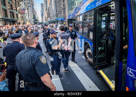 Più di 40 membri dell'azione diretta di gruppo e aumento di resist sono stati arrestati dopo la chiusura di ora di punta del traffico in corrispondenza dell'intersezione tra la 42nd Street e la Fifth Avenue nel cuore di New York City sulla luglio 15, 2019 raccomanda per i diritti degli immigrati ed esigente pubblico wake up, agire, e alla fine la crisi di confine il terrore e il terrore inflitti alla comunità di immigrati. Gli attivisti detenuti tre banner che leggere "chiudere i campi", "No RAID", e "Abolire il ghiaccio". Alcuni membri indossava inoltre fluorescente giubbotti di lavoro con le parole "Abolire ghiaccio." (Foto di Erik McGregor/Pacific Stampa) Foto Stock