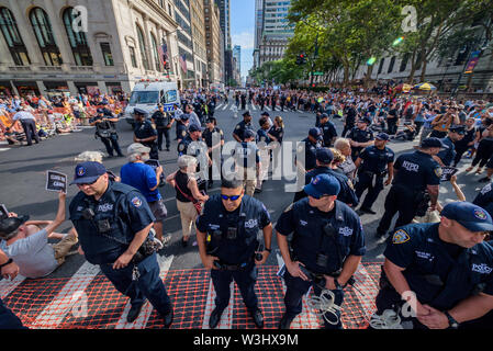 Più di 40 membri dell'azione diretta di gruppo e aumento di resist sono stati arrestati dopo la chiusura di ora di punta del traffico in corrispondenza dell'intersezione tra la 42nd Street e la Fifth Avenue nel cuore di New York City sulla luglio 15, 2019 raccomanda per i diritti degli immigrati ed esigente pubblico wake up, agire, e alla fine la crisi di confine il terrore e il terrore inflitti alla comunità di immigrati. Gli attivisti detenuti tre banner che leggere "chiudere i campi", "No RAID", e "Abolire il ghiaccio". Alcuni membri indossava inoltre fluorescente giubbotti di lavoro con le parole "Abolire ghiaccio." (Foto di Erik McGregor/Pacific Stampa) Foto Stock