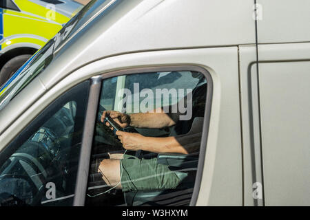 Londra, Regno Unito. Il 15 luglio 2019. Un driver utilizza il suo telefono cellulare mentre si guida ponte di Waterloo, depite guidando attraverso la scorta della polizia per l'estinzione della ribellione marzo. Credito: Guy Bell/Alamy Live News Foto Stock