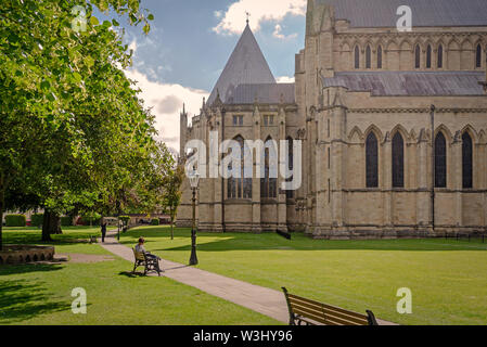 Sul lato nord della cattedrale di York Minster. I giardini sono da un lato e il Minster sull'altro. Un percorso curve tra i due con panchine ad intervalli. Foto Stock