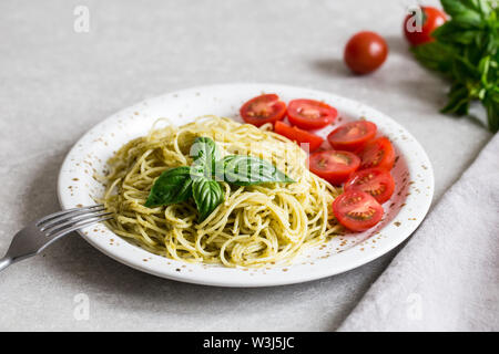 Spaghetti con fatti in casa al pesto, le foglie di basilico e pomodori Foto Stock