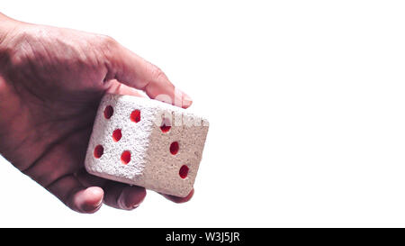 Manuali e a lanciare un dado. Rulli a mano a dadi bianco su sfondo isolato. Messa a fuoco selettiva. Dadi è la sfocatura dovuta al movimento. Lancia i dadi concept Foto Stock