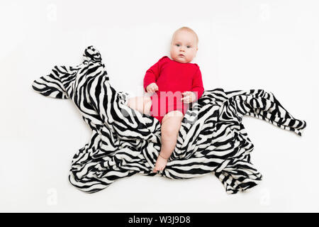 Divertente simpatico baby sitter sul cavallo giocattolo o zebra e sorridente Foto Stock