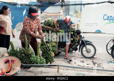 Vietnamita trasporto uomo molti banana mazzetto in moto il giorno, banane è popolare del prodotto di agricoltura in Vietnam, città di Ho Chi Minh Foto Stock