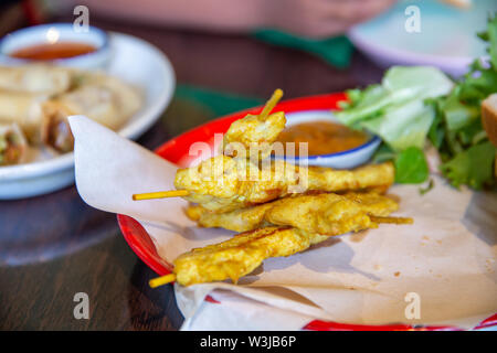 Pollo satay su spiedini di legno con salsa di arachidi Foto Stock