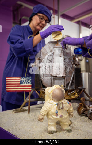 Cadbury World cioccolatieri Alba Jenks e Donna Oluban aggiungere il tocco finale per il loro cioccolato ricreazione dell'Apollo 11 atterraggio sulla luna a Cadbury World in Birmingham, per contrassegnare 50 anni al giorno dato che la missione di noi per portare gli uomini sulla Luna sollevata. Foto Stock