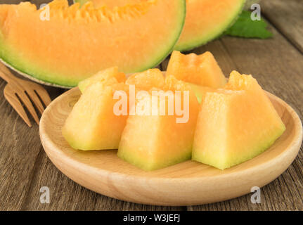 Fresco affettato pezzi di melone in lastra di legno. Foto Stock