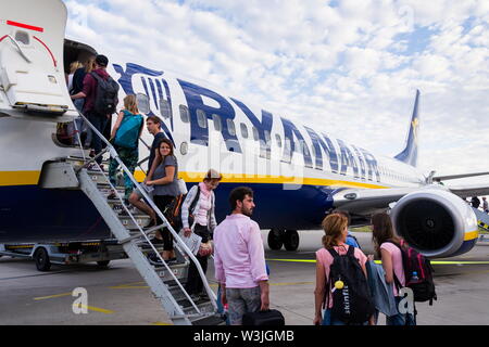 MEMMINGEN, Germania - 6 Luglio 2019: persone imbarco irlandese Ryanair compagnia aerea low-cost aereo Boeing 737 con sfondo con cielo nuvoloso su luglio 6, 2019 in Memmin Foto Stock