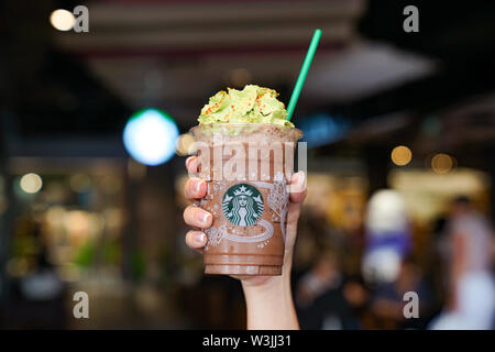 BANGKOK, Tailandia - 15 Novembre, 2017: Starbuck souviniers e bevande disposte in linea sul tavolo di legno con blur sullo sfondo, per presentare le ho Foto Stock