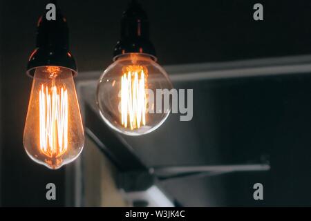 Primo piano di due grandi lampadine illuminate al buio sfondo Foto Stock