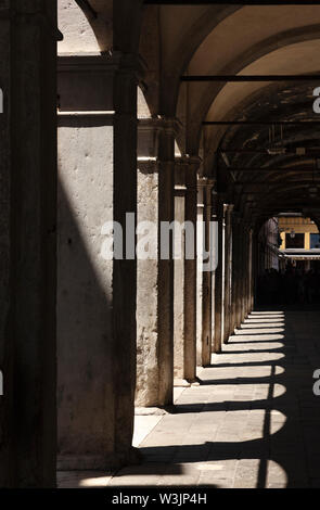 Ritratto di luci e ombre all'interno di un arco di pietra, Venezia, Italia Foto Stock