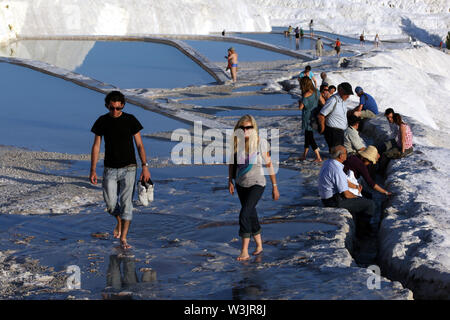 I turisti a piedi attraverso le piscine termali all'travertini (Castello di Cotone) a Pamukkale in Turchia. Foto Stock