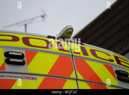 Un 'Polizia' segno sulla parte posteriore porte doppie di una polizia van che mostra le scritte in nero su sfondo giallo e arancio e giallo freccette. Foto Stock