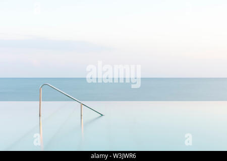 Piscina infinity e ferrovia con il mare, Cittanova, Istria, Croazia Foto Stock