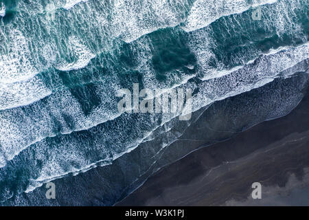 Antenna fuco vista oceano Atlantico onde lavaggio basaltica nera spiaggia di sabbia, Islanda Foto Stock