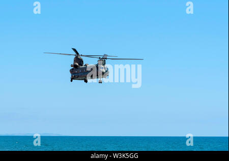 Sidmouth, Devon, in Inghilterra una RAF Chinook il sollevamento pesante elicottero volando lungo la costa sud occidentale a Sidmouth, nel Devon, Regno Unito Foto Stock