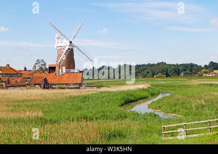 Una vista di Cley Windmill con il fiume Glaven fluente attraverso canneti sulla Costa North Norfolk a Cley-next-Mare, Norfolk, Inghilterra, Regno Unito, Europa. Foto Stock