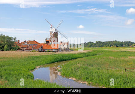 Una vista di Cley Windmill con il fiume Glaven fluente attraverso canneti sulla Costa North Norfolk a Cley-next-Mare, Norfolk, Inghilterra, Regno Unito, Europa. Foto Stock