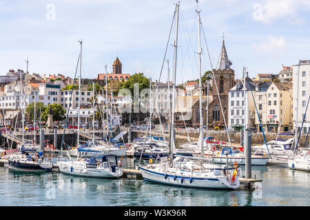 Yacht ormeggiati nel porto di fronte della chiesa del paese, St Peter Port Guernsey, Isole del Canale della Manica UK Foto Stock