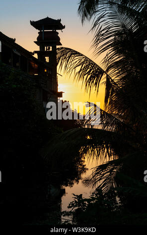 Tramonto dietro un tempio indù sulla spiaggia in corrispondenza di Lovina, nord di Bali, Indonesia. Foto Stock