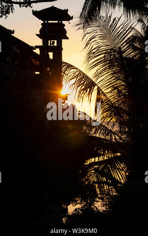 Tramonto dietro un tempio indù sulla spiaggia in corrispondenza di Lovina, nord di Bali, Indonesia. Foto Stock