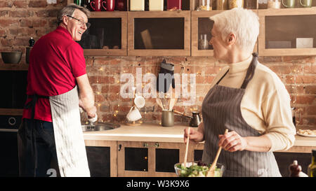 Felice Coppia sorridente ad ogni altra spesa sera in cucina Foto Stock