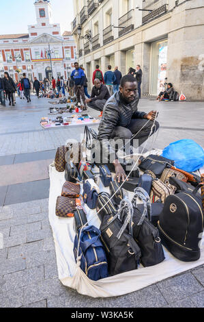 Gli immigrati counerfeit vendita merci sulle strade di Madrid vicino alla Puerta del Sol, centro di Madrid, Spagna. Foto Stock