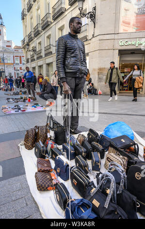 Gli immigrati counerfeit vendita merci sulle strade di Madrid vicino alla Puerta del Sol, centro di Madrid, Spagna. Foto Stock