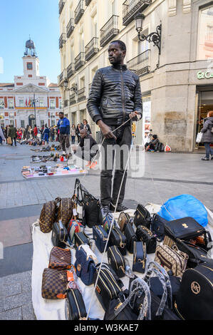 Gli immigrati counerfeit vendita merci sulle strade di Madrid vicino alla Puerta del Sol, centro di Madrid, Spagna. Foto Stock
