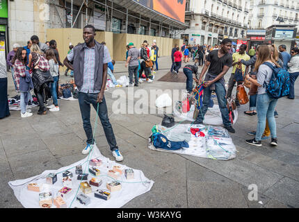Gli immigrati counerfeit vendita merci sulle strade di Madrid vicino alla Puerta del Sol, centro di Madrid, Spagna. Foto Stock