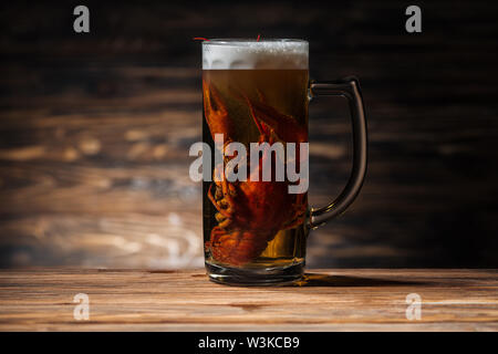 Red Lobster in vetro con una birra su di una superficie di legno Foto Stock