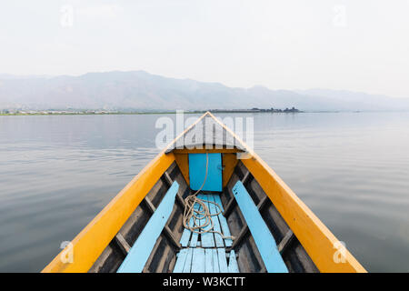 Barca di legno tradizionale naso con Lago Inle e le montagne sullo sfondo, Myanmar. Foto Stock