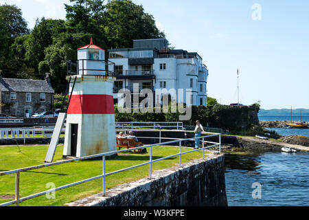Crinan faro in mare lock (blocco 15) con Crinan Hotel in background a Crinan villaggio sul Crinan Canal, Argyll and Bute, Scotland, Regno Unito Foto Stock