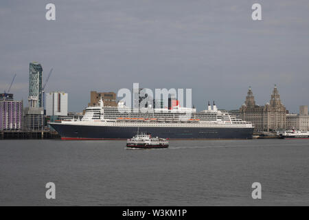 Liverpool, Regno Unito. Il 16 luglio 2019. Il Traghetto Mersey Royal Iris passa di fronte al Queen Mary 2 ancorata in Liverpool. Il 149,000 t per nave il più grande transatlantico mai costruito è in piena vista oggi mentre ormeggiata presso la città di crociera del terminale della camicia. 300 passeggeri potranno unirsi a lei come parte di un transatlantico di viaggio a New York via Reykjavik e Halifax, Nova Scotia. Credito: Ken Biggs/Alamy Live News Foto Stock
