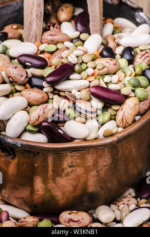 Zuppa di legumi secchi e cereali mescolati in una pentola di rame su tavola in legno rustico.still life Foto Stock