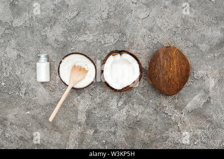 Lay piatto con noci di cocco e crema di noce di cocco sul grigio Sfondo testurizzata Foto Stock
