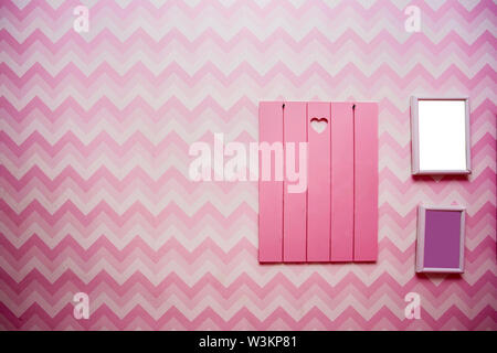 Fustellato cornici in legno di rosa sulla parete a strisce, spazio vuoto per il testo, rosa e viola design retrò Foto Stock