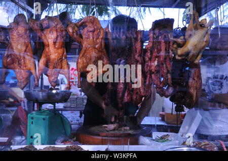 L anatra arrosto essendo sminuzzati, w/ una carne intelligente, da un venditore ambulante al mercato russo. Phnom Penh Cambogia. Credito: Kraig Lieb Foto Stock