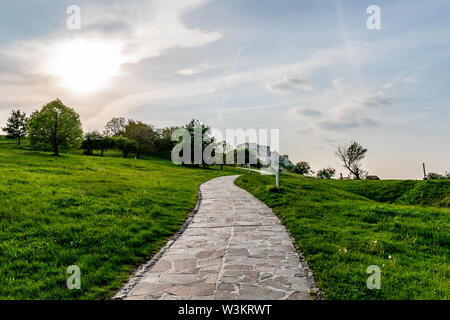 Il Castello di Devin principale pietra lastricata strada conduce alla rovina cinto di mura fortificate con sfondo con cielo nuvoloso Foto Stock