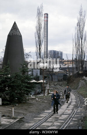 11 aprile 1993 durante l'assedio di Sarajevo: in vista di assediano cecchini serbi, una donna e uomo correre lungo un binario morto vicino alla giunzione di Hamdije Cemerlica e mettere zivota (noto come Bratstva i jedinstva e Kranjcevica nel 1993). Foto Stock