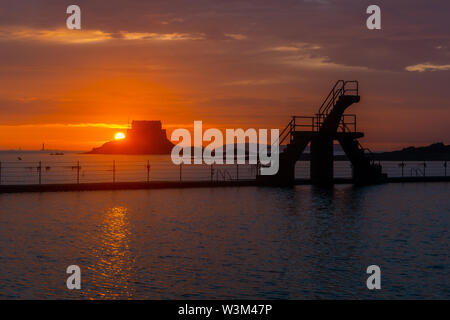 Tramonto dietro il Fort du Petit Bé con il Bon Secours piscina al primo piano, St Malo bellissimo scenario, Brittany, Francia. Foto Stock
