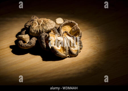 Gruppo di secche Funghi Shitake posa sul banco di bambù. ingrediente alimentare. Foto Stock