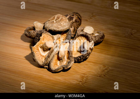 Gruppo di secche Funghi Shitake posa sul banco di bambù. ingrediente alimentare. Foto Stock