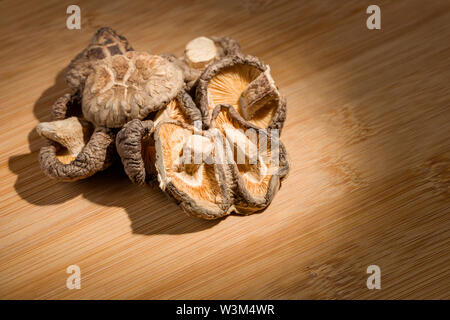 Gruppo di secche Funghi Shitake posa sul banco di bambù. ingrediente alimentare. Foto Stock