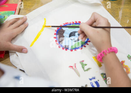 Vista superiore del bambino disegna le mani un gouache su carta. Gouache e carta per pittura e disegno del bambino. Kid mani pittura a tavola con arte materiali di consumo, Foto Stock