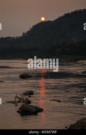 Vista di un fiume nave da crociera sul fiume Mekong e Chomphet District attraverso il fiume a Luang Prabang, Laos, al tramonto. Foto Stock