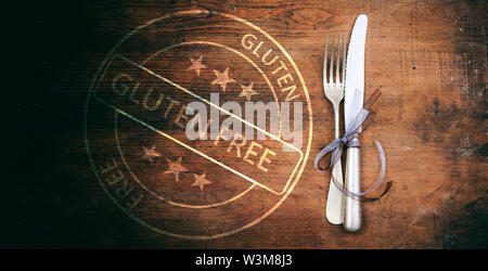 Senza glutine menu certificata, mangiare sano concetto. Esente da glutine timbro e set di posate su tavola in legno rustico, vista dall'alto. Foto Stock